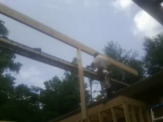 Carpenter setting a ridge beam over a new addition frame — Ice Dam Removal by Roofing Brothers in Amarillo
