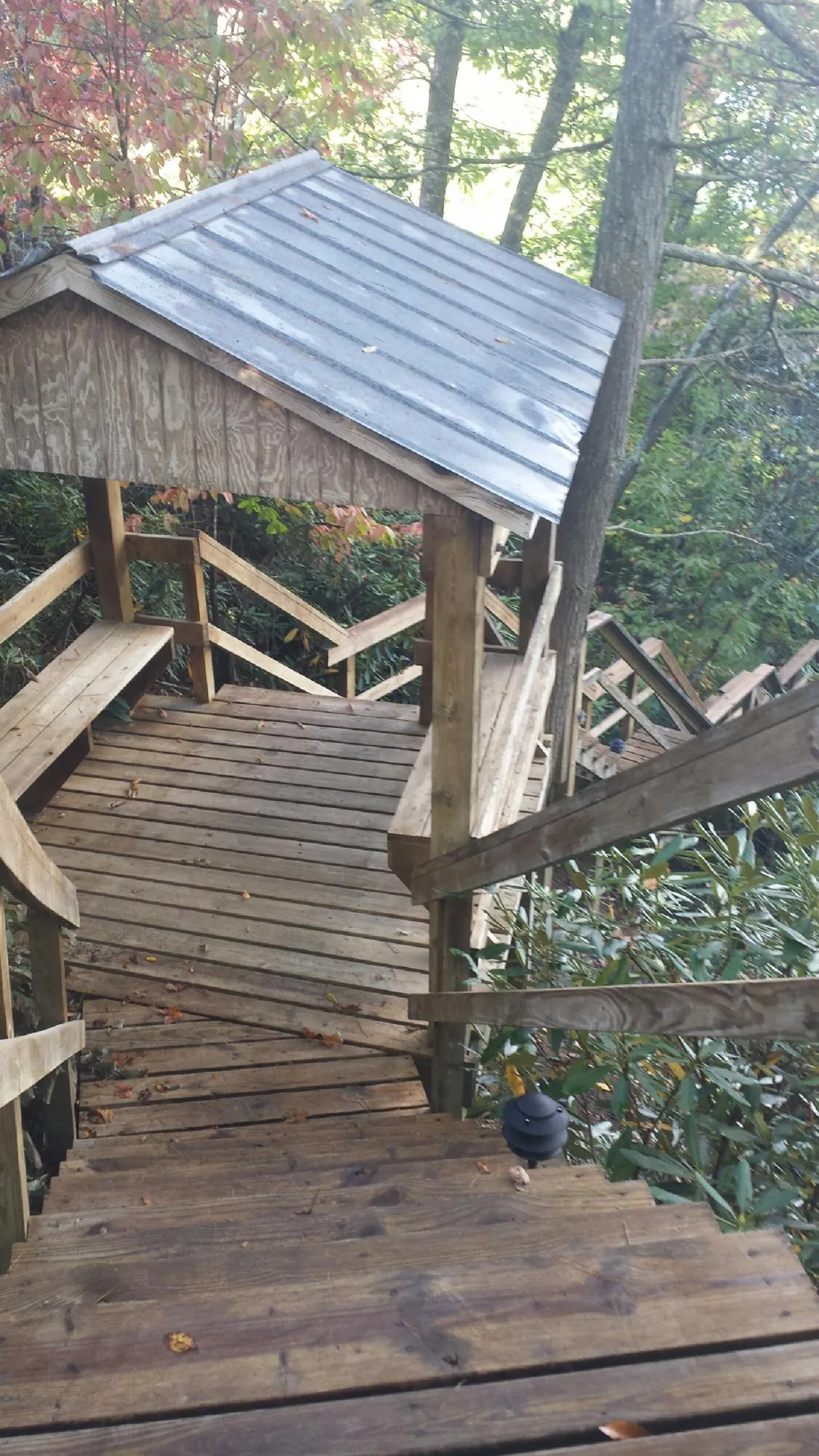 Metal roofed shelter over wooden steps on a wooded walkway — Skylight Repair & Installation work by our crew in Amarillo